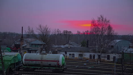 timelapse of dramatic sunset over bahnhof , oil tank cars standing still in the backyard, germany