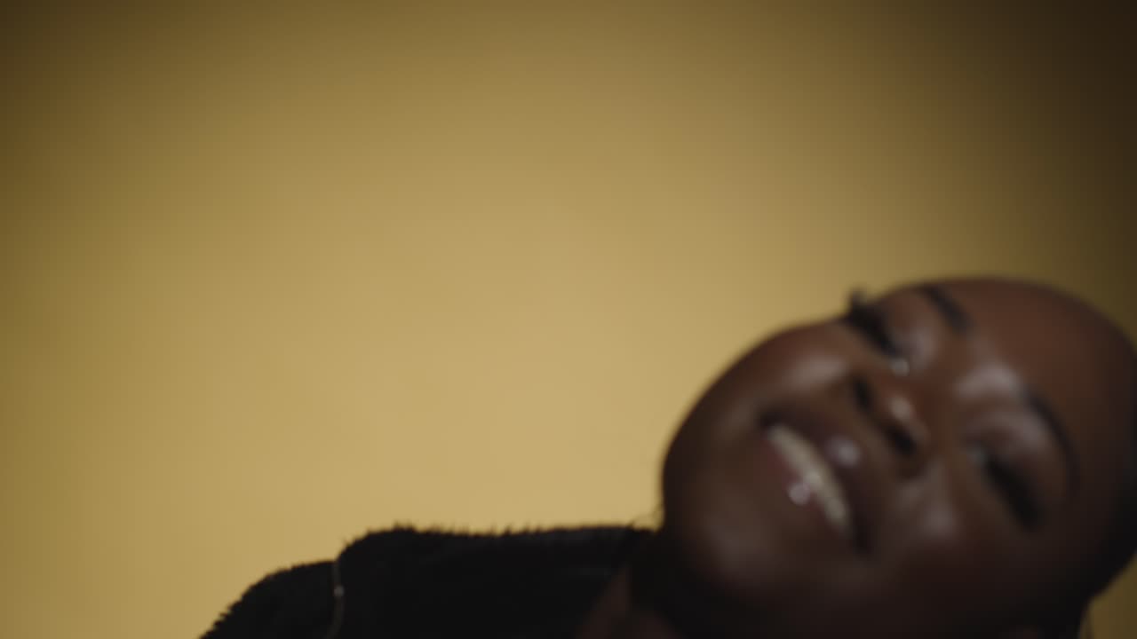 cabeza y hombros estudio retrato de una mujer joven bailando en el centro de atención contra un fondo amarillo 2