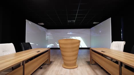 sala de conferencias moderna con mesas de madera, sillas de cuero y un podio central