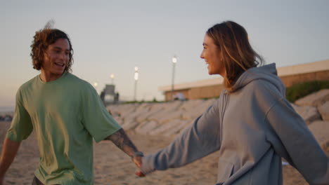 carefree couple having fun at evening beach close up. teenagers rejoicing ocean