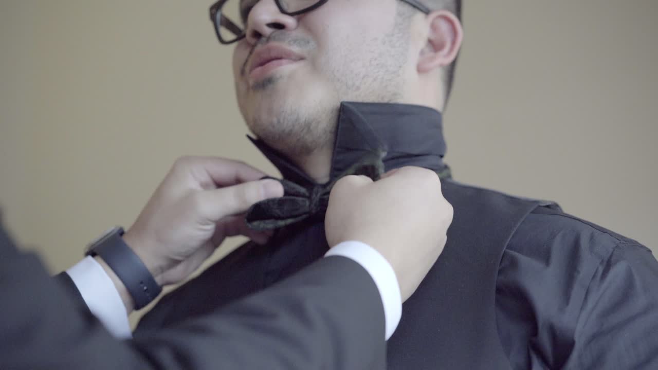 신랑 은 결혼식 과 사진 을 위해 나비  ⁇ 타이 를  ⁇ 는다