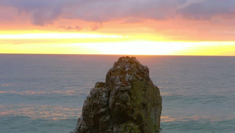 Beautiful-Sunrise-with-Calm-Ocean-behind-a-Cormorant-on-top-of-Cathedral-Rocks-near-Kiama-Downs,-NSW-Australia