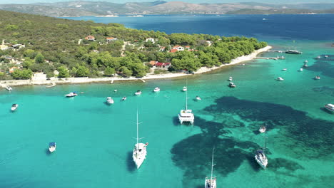 aerial view of blue lagoon with yachts, catamaran and motorboats anchor in turquoise blue water in drvenik veli, croatia