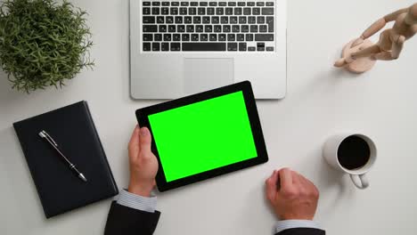 las manos de un hombre sosteniendo una tableta digital con una pantalla verde
