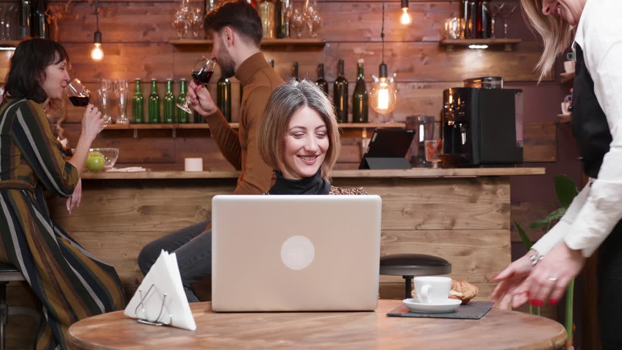People working and socializing in a bar setting