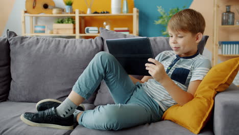 boy using tablet on a couch