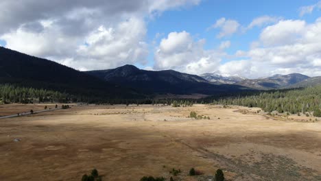 Slow-pedestal-about-the-beautiful-views-of-the-Tahoe-national-park,-with-endless-open-fields-and-snowy-mountains-in-the-background,-on-a-bright-and-a-little-cloudy-day