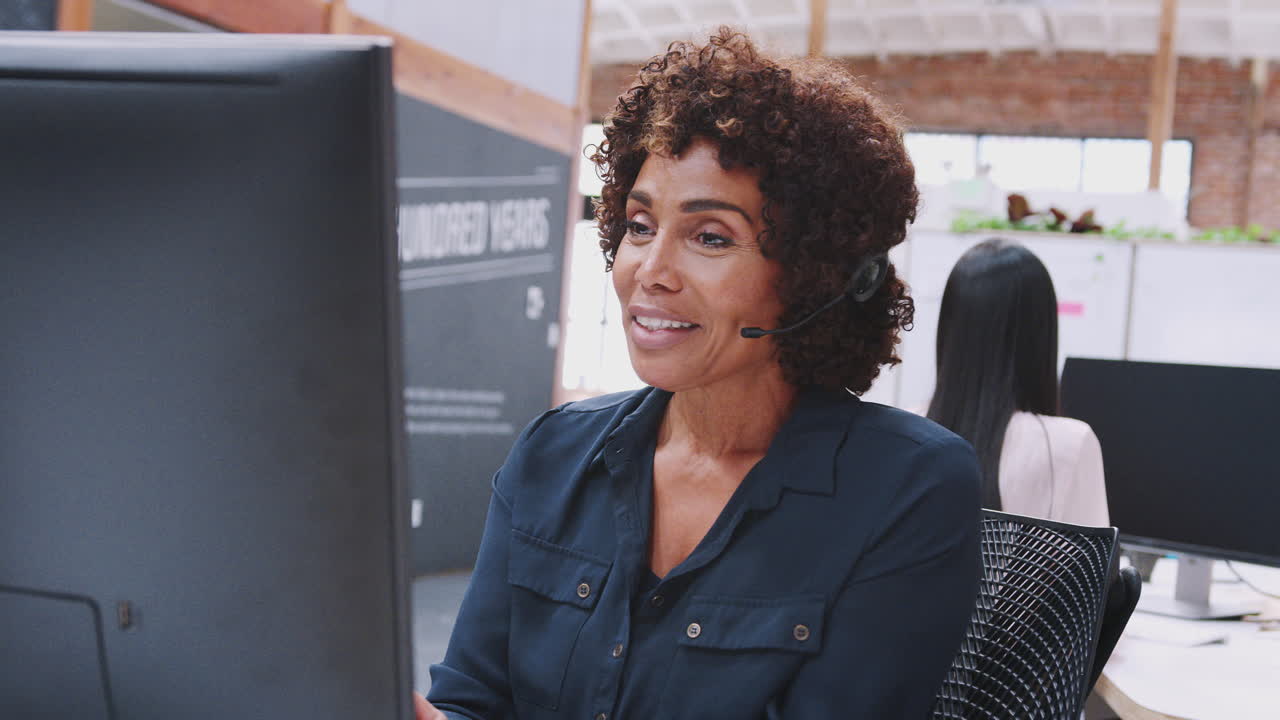 agente de servicios al cliente mujer madura trabajando en el escritorio en el centro de llamadas