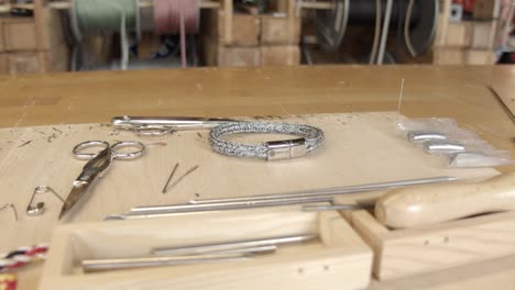 Wooden-jewellery-making-workstation-with-tools-and-bracelet