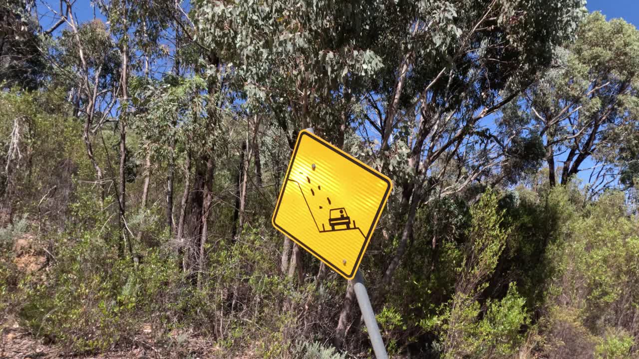señal de advertencia amarilla en medio de la densa selva australiana