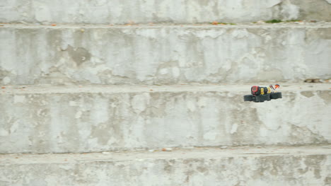 a sports drone with a camera flies quickly against a white wall follow shot