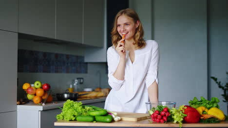 chica feliz comiendo zanahorias en la cocina. alimentación saludable. comida vegetariana