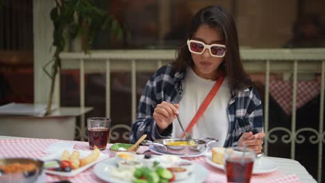 una mujer joven disfrutando de un desayuno turco.