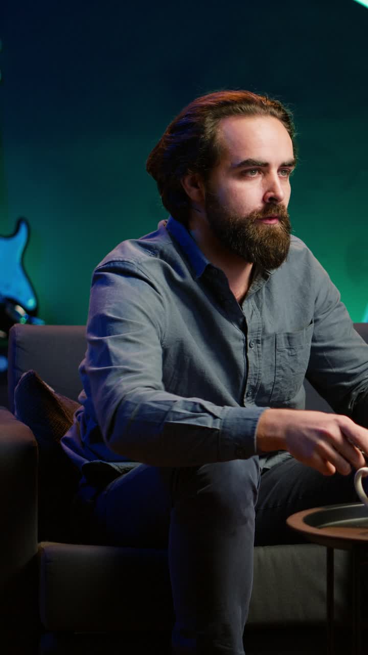 Vertical video Man at home shocked by troubling events broadcasted on TV, calling friend