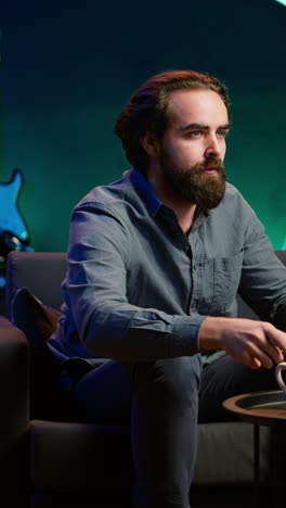 vertical video man at home shocked by troubling events broadcasted on tv, calling friend