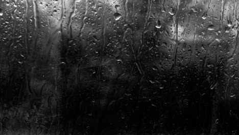 raindrops with copy space. heavy downpour outside the window at night, background of water drops on glass in the dark