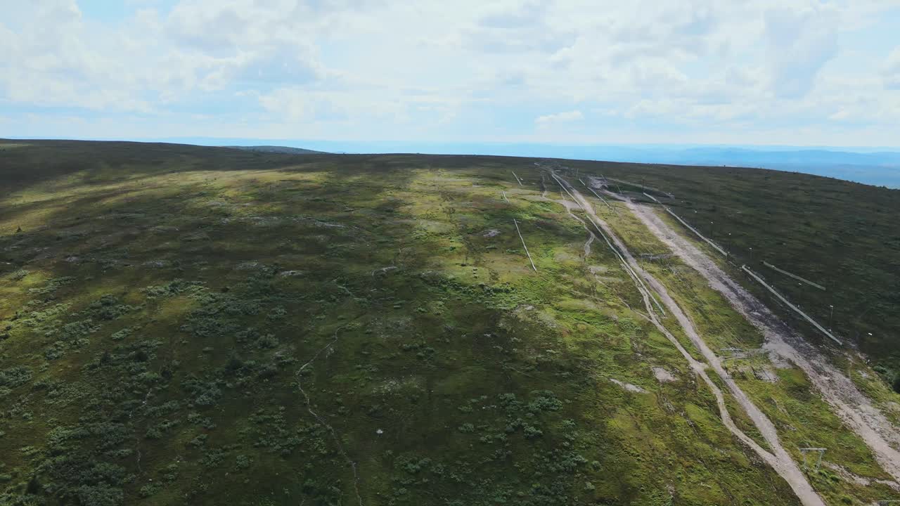 camino de tierra a través de prados verdes en högfjällshotellet, sälen, dalarna, suecia - toma aérea de drones