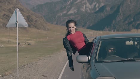 happy woman in leather jacket looks down with extended arms