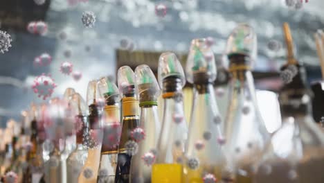 multiple covid-19 cells icons floating against colourful syrup glass bottles in background