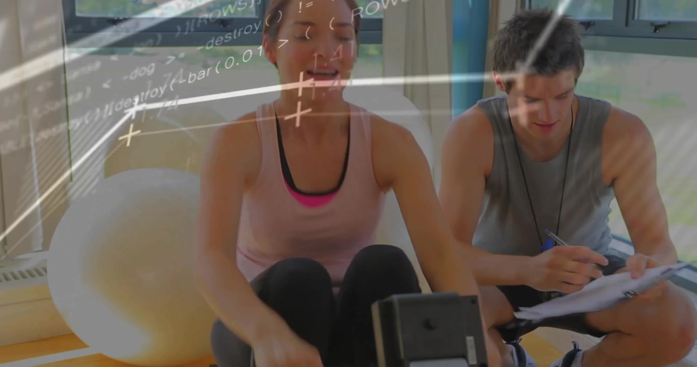 Entrenador de fitness aplaudiendo para iniciar el cronometraje de un cliente remando mientras un gráfico animado aparece en la tableta.