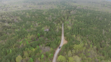 aerial footage birds eye view following a black truck driving on a dirt road in the sequatchie valley in east tennessee