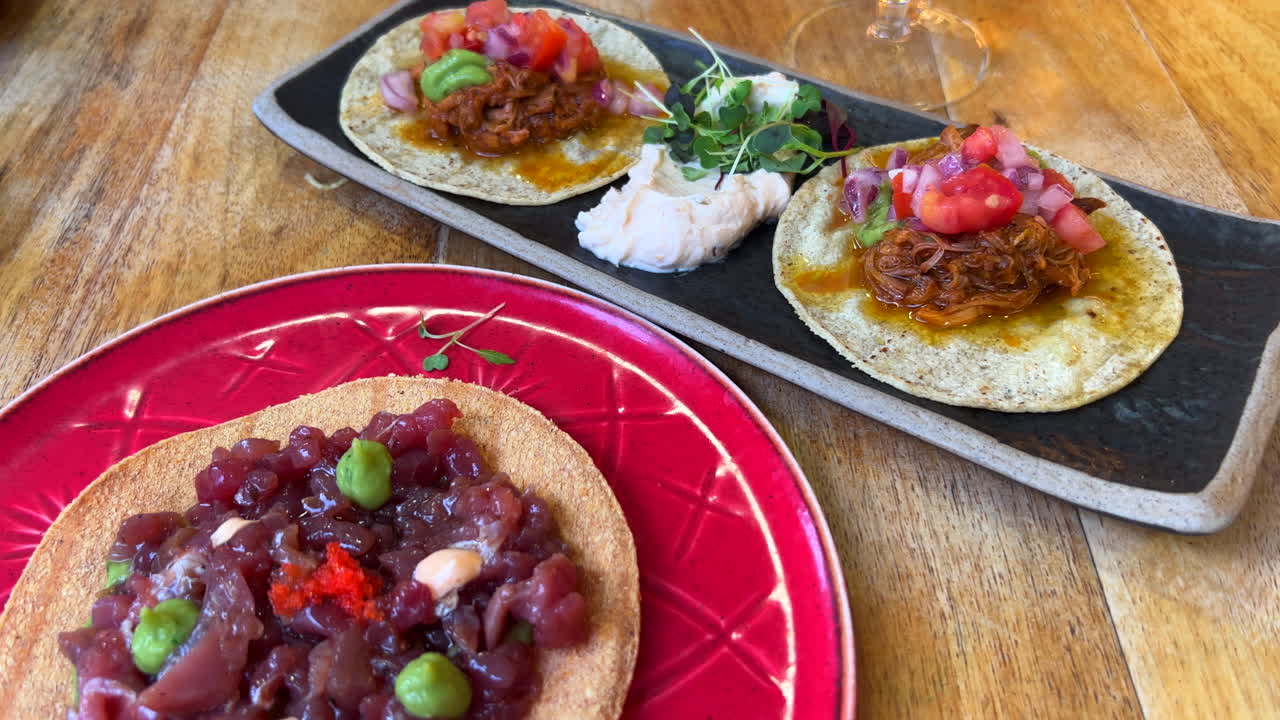 Tacos suculentos de cochinita pibil mexicana cozida lentamente e taco de tartare de atum, filmagem em 4K.