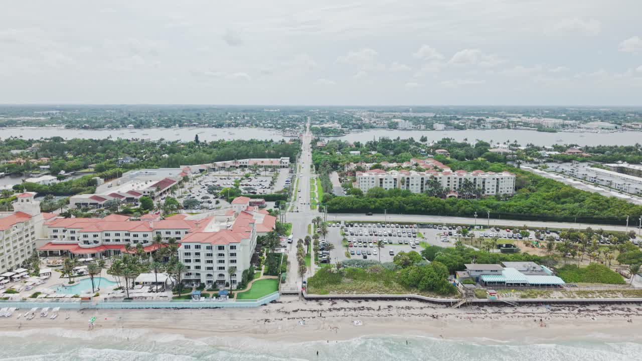 Aerial: roads and cityscape with cloudy weather during the day in West Palm Beach, Florida, USA, pull out drone shot