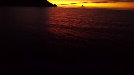 Aerial-shot-over-the-water-revealing-an-orange-sunset-on-Lake-Titicaca-in-Peru