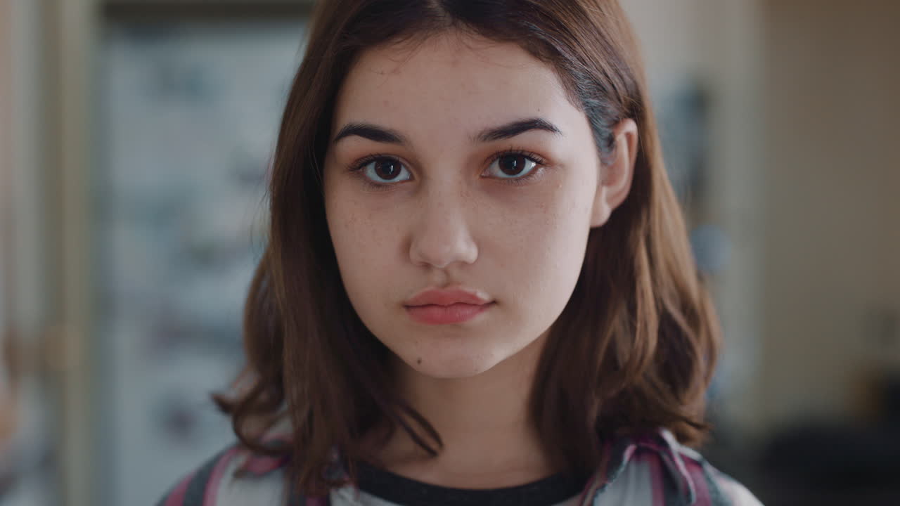 retrato de una hermosa adolescente en la cocina en casa buscando una expresión seria