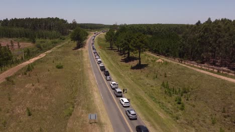 aerial flyover rural road with traffic jam at border between argentina and uruguay during sunny day