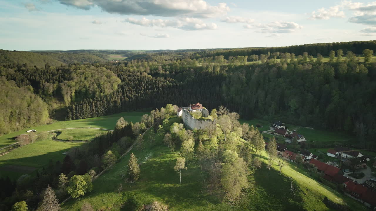 Tasainen 4K UHD -drooni kiertää Burgruine Hohengundelfingenin kalkkikivikukkulaa, ja taustalla näkyvät Große Lautertalin metsät ja niityt