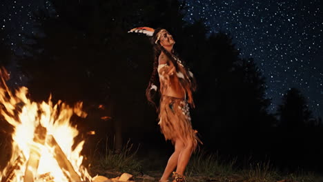 Woman in Native American Costume Dancing by Fire at Night