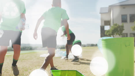 Animation-of-bokeh-light-spots-over-diverse-schoolboys-in-recycling-t-shirts-collecting-plastic