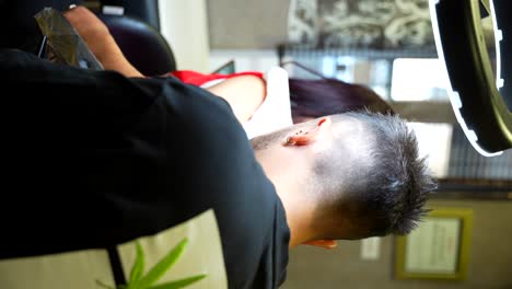 man getting a tattoo at a tattoo parlor