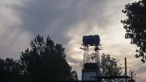 time lapse of cloudy day landscape with water tank tower