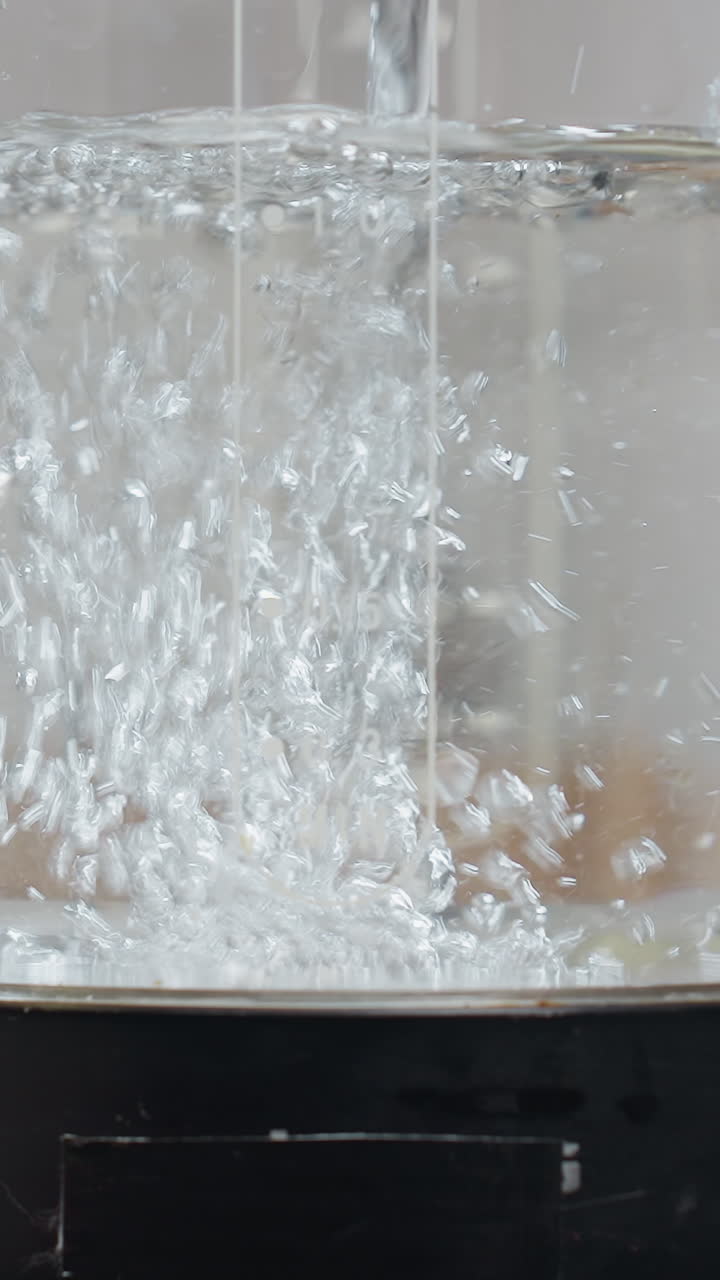 현대 가전제품이 있는 깨한 부에서 물 거품이 형성되고 그 위에 글자가 새겨져 있는 전기 물 항아리의 클로즈업