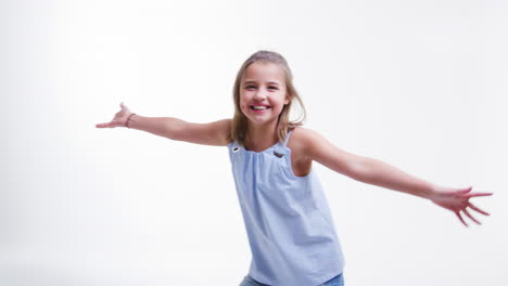 girl jumps into shot and dances against white studio background