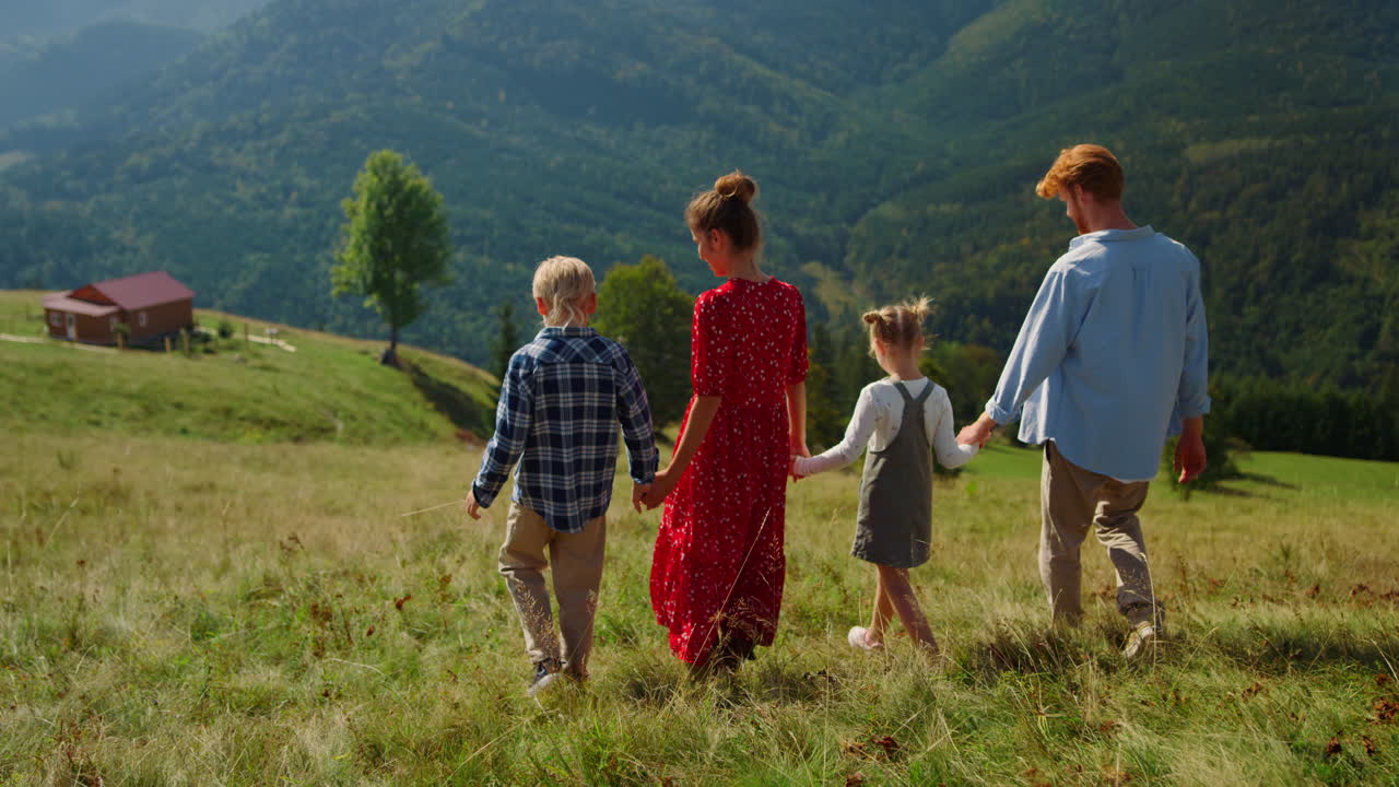 семья спускается по зеленому холму, люди наслаждаются летними каникулами.