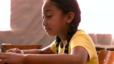 little girl using laptop in classroom