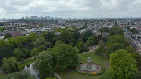 Sarphatipark-Public-Park-in-Amsterdam,-Forward-Aerial-on-Cloudy-Day