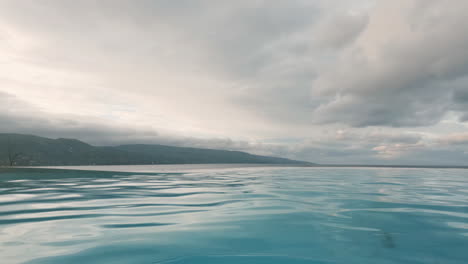 Ondas-Serenas-A-Través-De-La-Hermosa-Piscina-Infinita,-Bajo-Un-Cielo-Espectacular