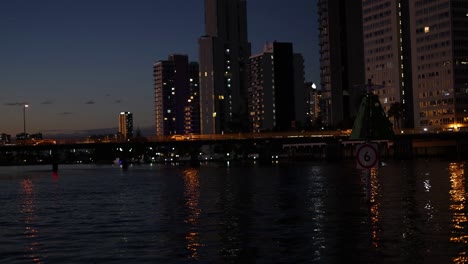 city buildings reflecting on canal at night