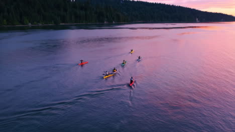 Kayakers on a Serene Lake at Sunset with Forested Shoreline