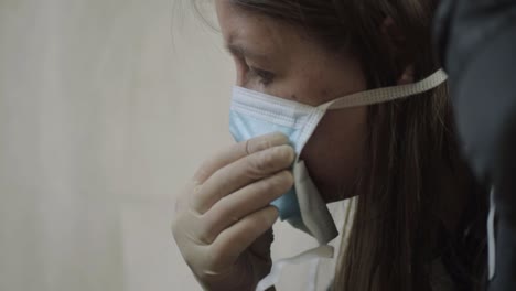 woman wearing surgical gloves putting on surgical mask medium head shot