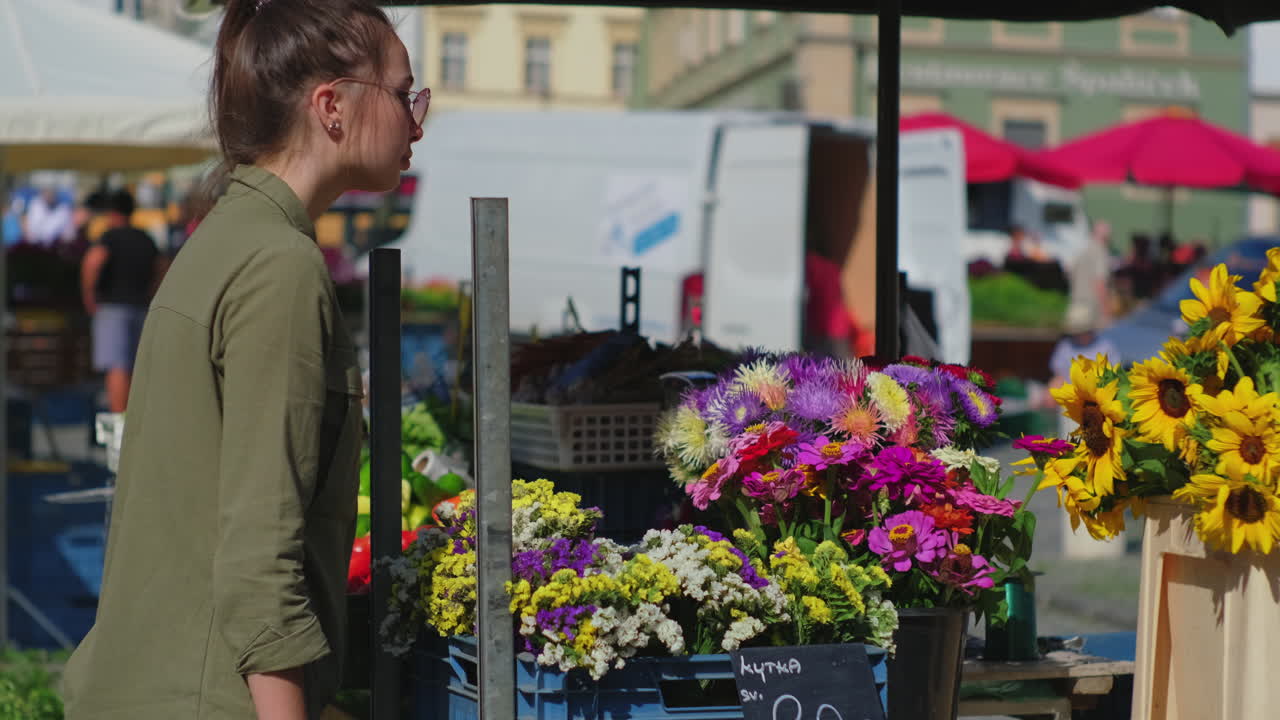 여자 가 거리 시장 에서 꽃 을 구입 하고 있다