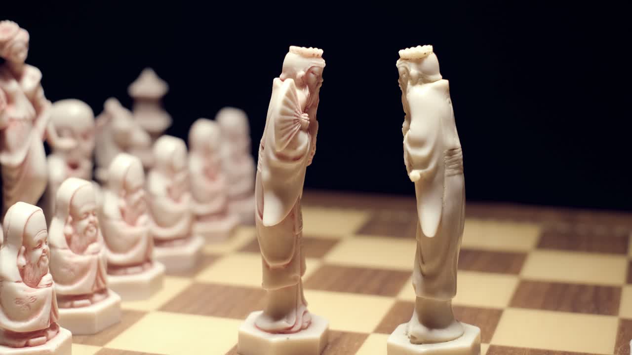 A close up shot of a rotating chessboard, the 2 kings are placed facing each other in the centre signifying a drawn match and part of the etiquette of the game