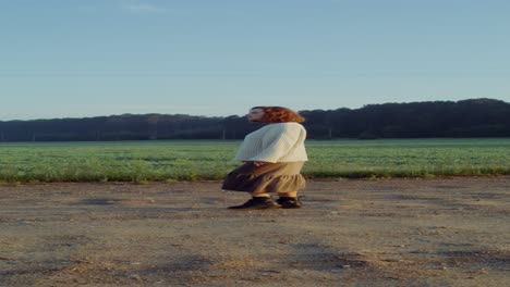 woman walking in a countryside field at sunrise