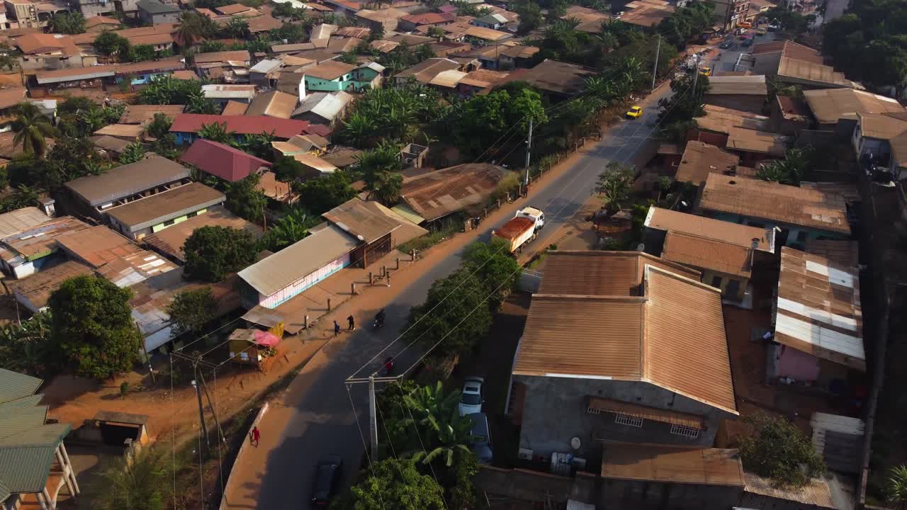 Drone shot tracking a gravel lorry, driving in Yaounde city, sunny day in Cameroon
