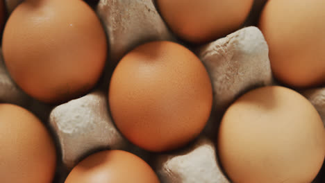 video of close up of brown eggs in egg carton background