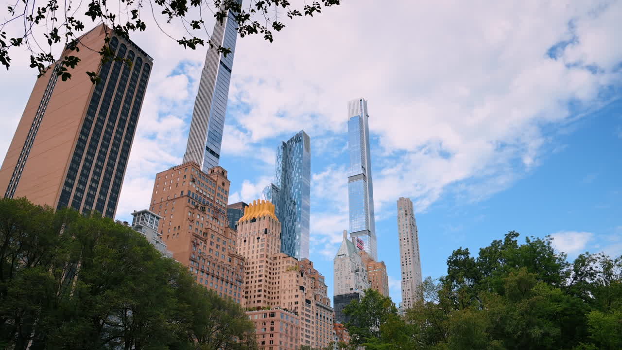 New York, USA, 28 July 2025: Stunning skyline in Central Park. Families and tourists enjoy a day in Central Park, surrounded by towering skyscrapers in Manhattan under a clear sky